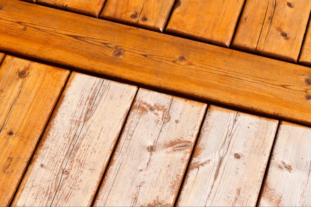 A closeup of a partially stained wood deck.