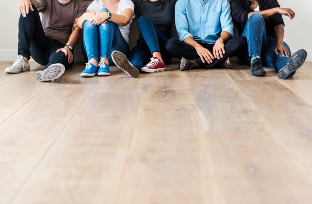 A photo of a group of friends sitting on the floor.