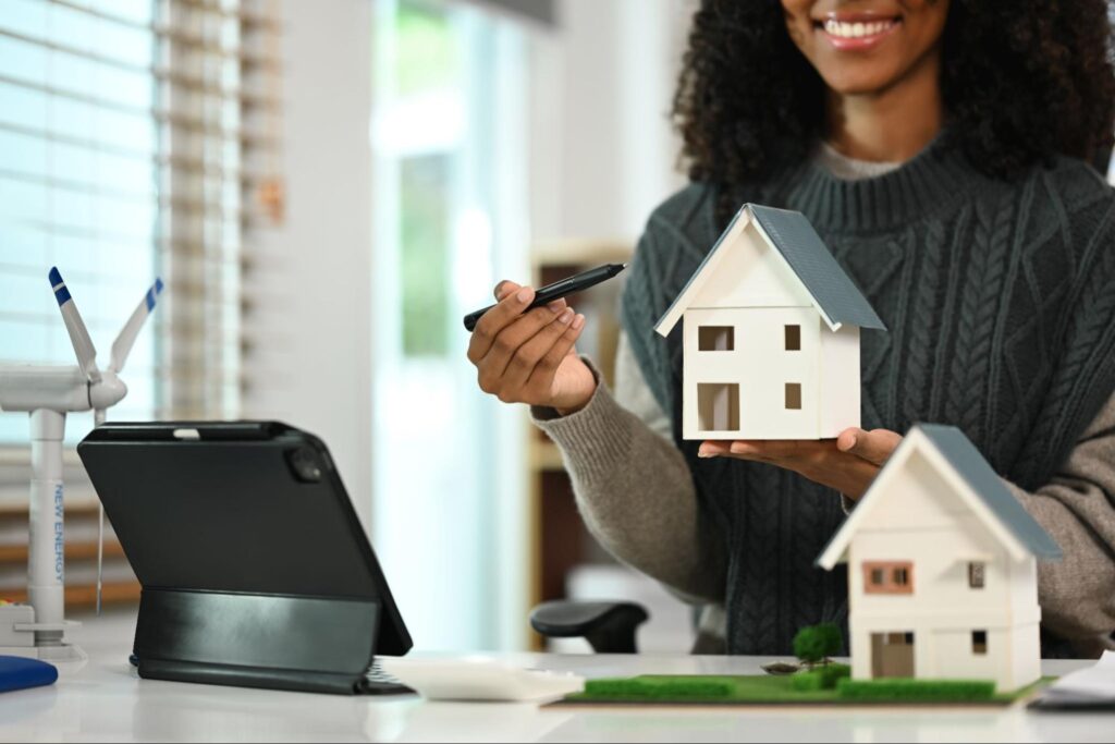 A woman showing a home model miniature. 