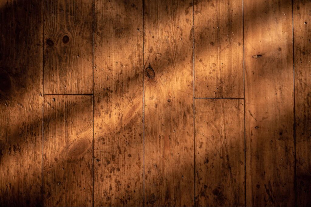 Wood flooring with a shadow covering it. 